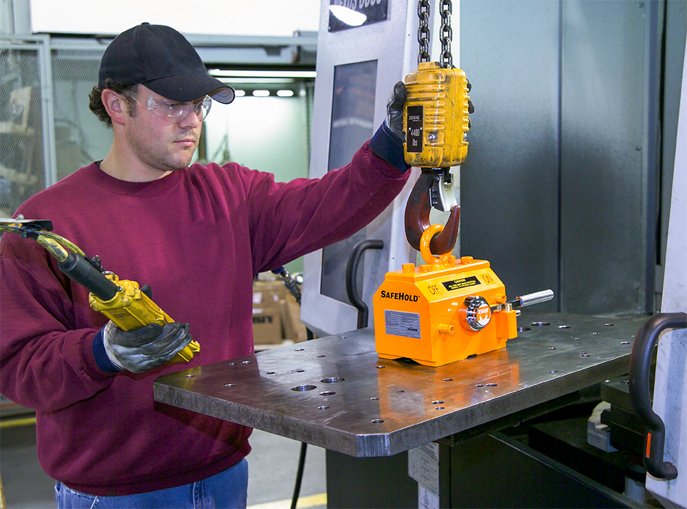 OurVision an employee using a lift magnet to lift a metal plate
